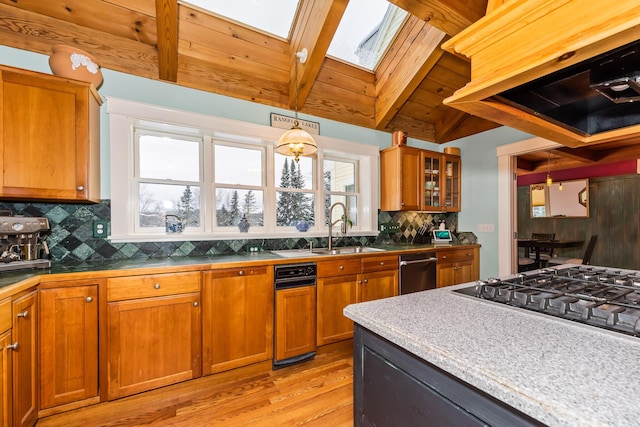 kitchen with beam ceiling, a skylight, range hood, light hardwood / wood-style floors, and decorative light fixtures