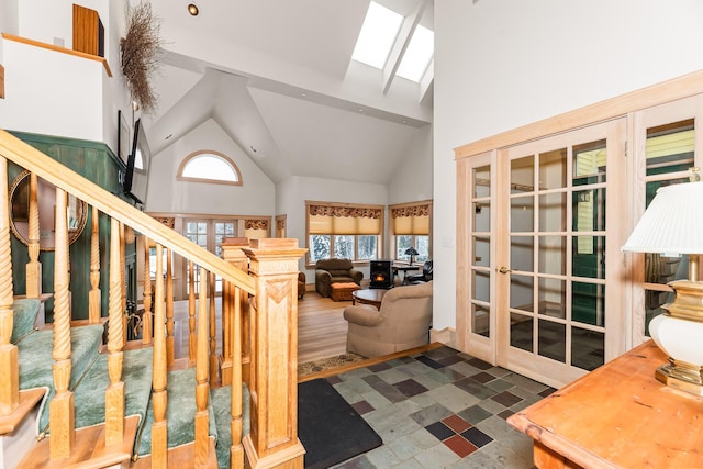 interior space featuring a skylight, high vaulted ceiling, and a healthy amount of sunlight