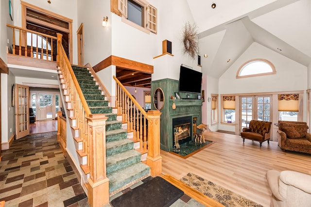 living room with a wealth of natural light, french doors, high vaulted ceiling, and wood-type flooring