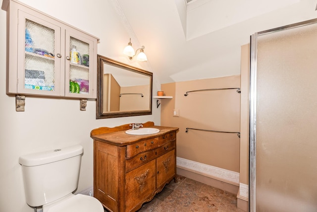 bathroom featuring vanity, toilet, and vaulted ceiling