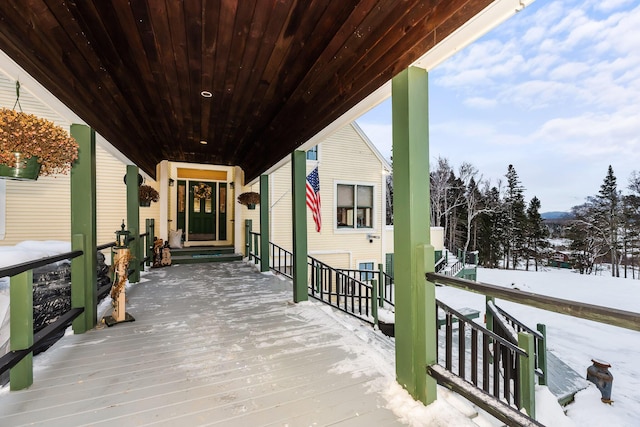 snow covered deck featuring a porch