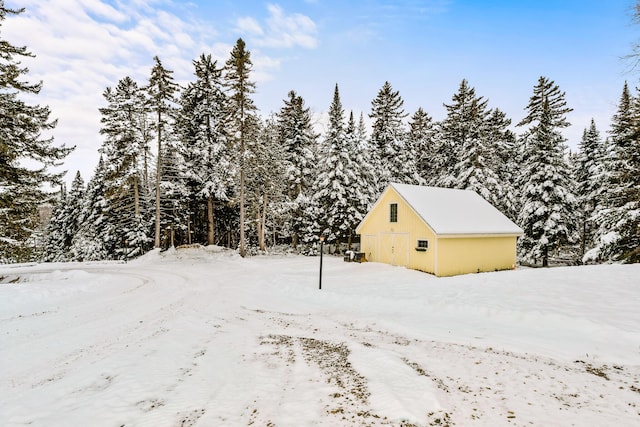 snowy yard featuring an outbuilding