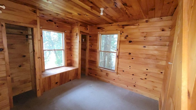 spare room featuring wood walls, wooden ceiling, and carpet floors