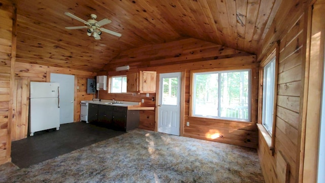 kitchen with white appliances, wooden walls, dark colored carpet, light brown cabinets, and lofted ceiling