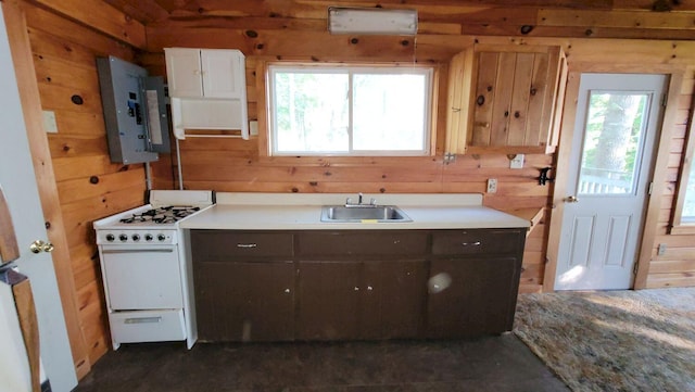 kitchen with wooden walls, white gas stove, and a healthy amount of sunlight