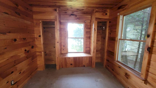 unfurnished room with wooden walls and wooden ceiling