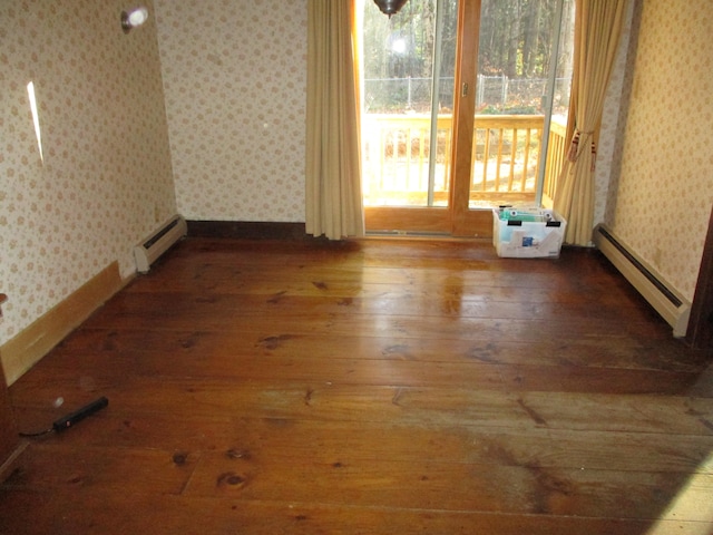 spare room featuring hardwood / wood-style floors and a baseboard heating unit