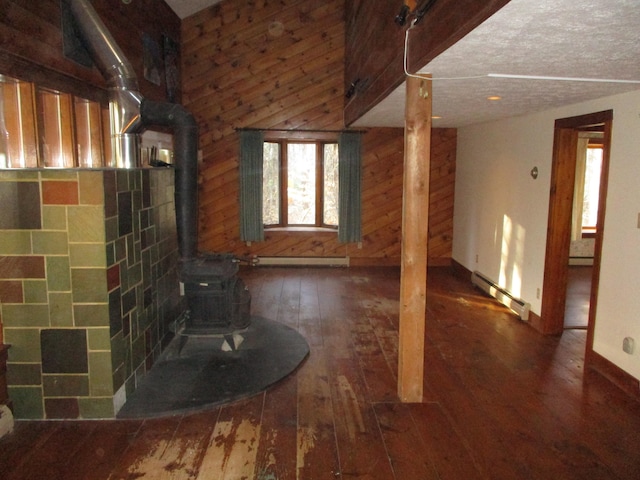 unfurnished living room with a textured ceiling, a wood stove, baseboard heating, and dark wood-type flooring