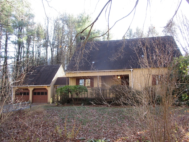 view of property exterior featuring a porch and a garage