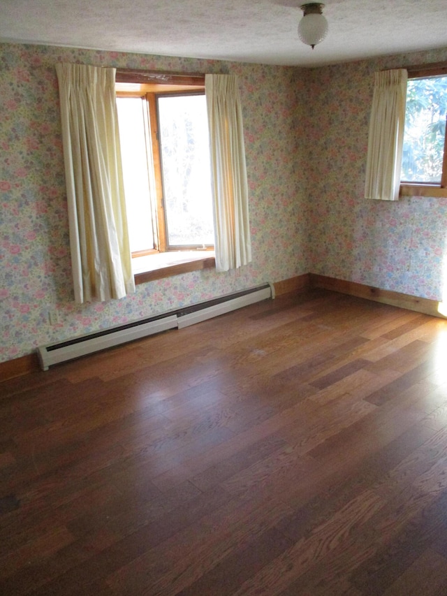 unfurnished room with a baseboard radiator and hardwood / wood-style flooring