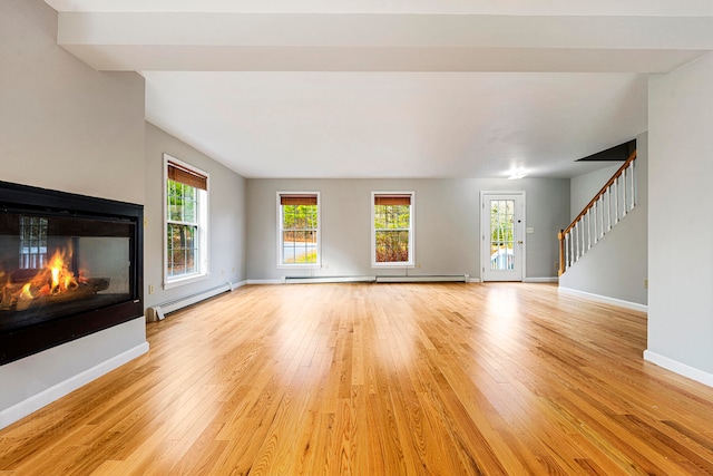 unfurnished living room featuring a multi sided fireplace, light wood-type flooring, and a baseboard heating unit