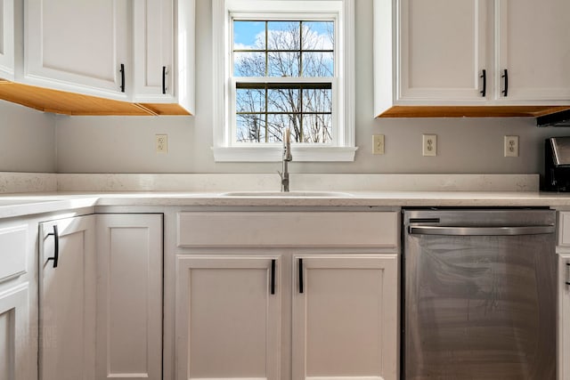 kitchen with dishwasher, white cabinets, and sink