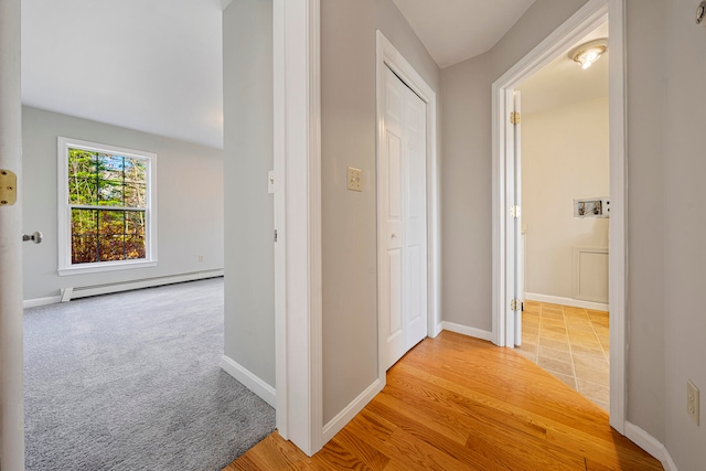 corridor featuring light hardwood / wood-style floors and a baseboard heating unit