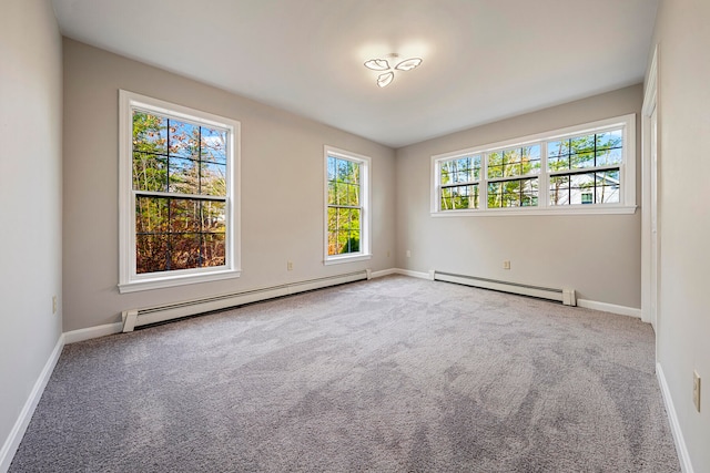 carpeted spare room featuring plenty of natural light and baseboard heating