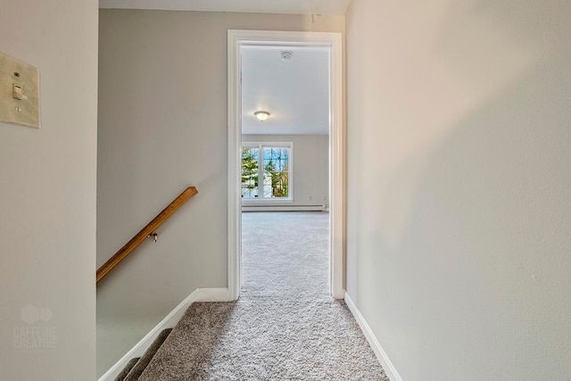 hallway with light colored carpet and a baseboard radiator