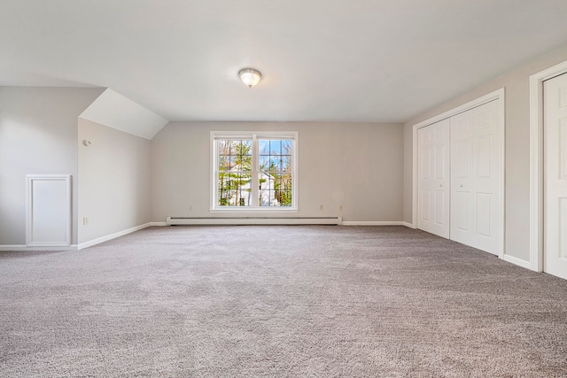 unfurnished bedroom with carpet, a baseboard radiator, and vaulted ceiling