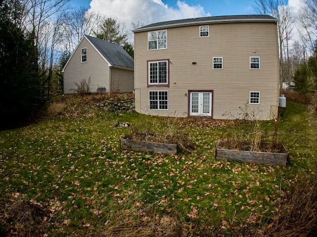 rear view of house featuring a lawn and french doors