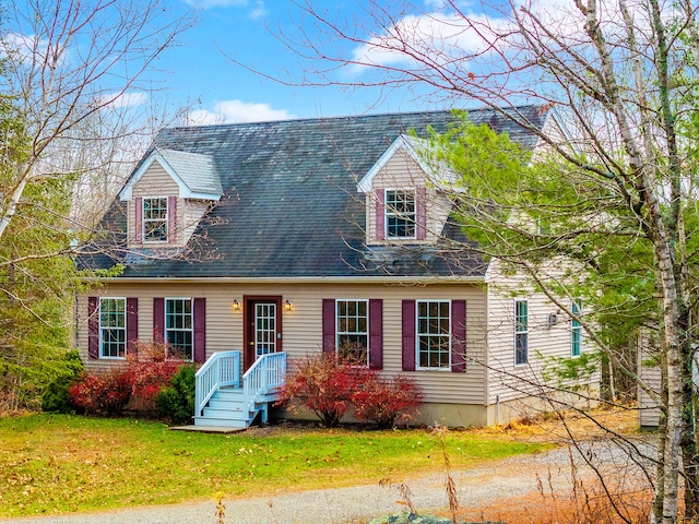 cape cod house featuring a front lawn