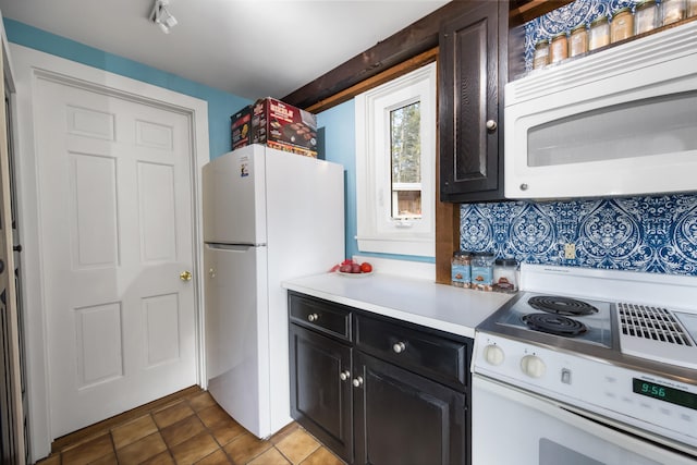 kitchen with light tile patterned flooring, white appliances, and backsplash