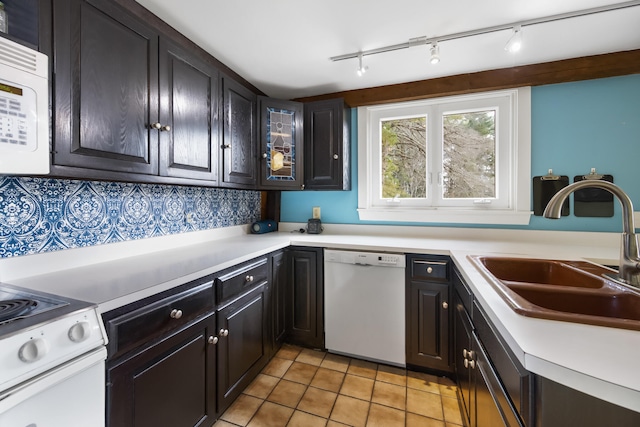 kitchen featuring sink, tasteful backsplash, white appliances, dark brown cabinets, and light tile patterned flooring