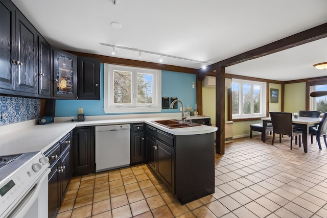 kitchen featuring sink, white appliances, kitchen peninsula, and a wealth of natural light