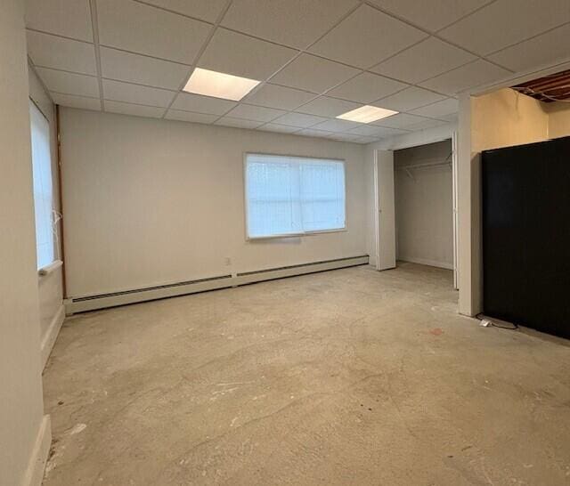 spare room featuring a drop ceiling and a baseboard radiator