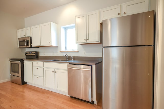 kitchen featuring white cabinets, sink, light wood-type flooring, and stainless steel appliances