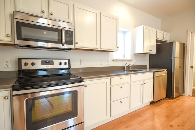 kitchen featuring white cabinets, light hardwood / wood-style floors, sink, and stainless steel appliances