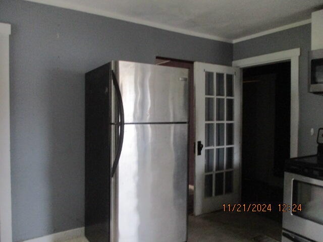 kitchen with crown molding and appliances with stainless steel finishes