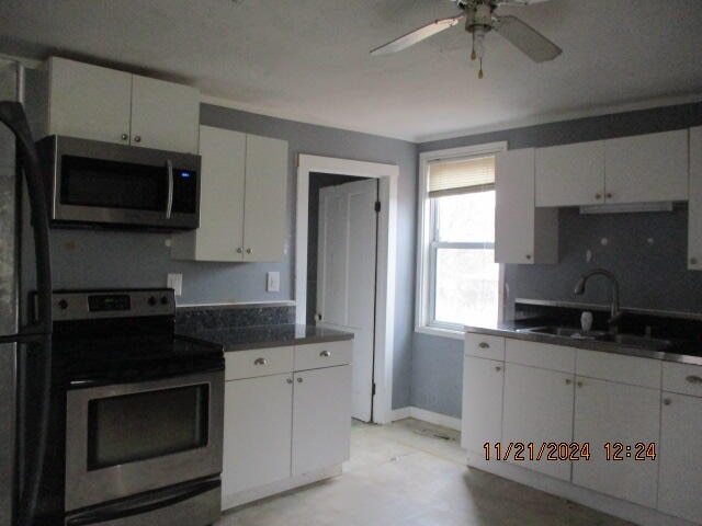 kitchen with white cabinets, stainless steel appliances, ceiling fan, and sink