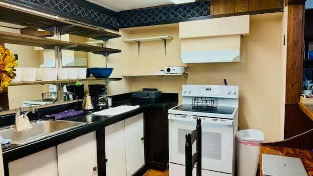 kitchen featuring white cabinets, electric range, range hood, and sink