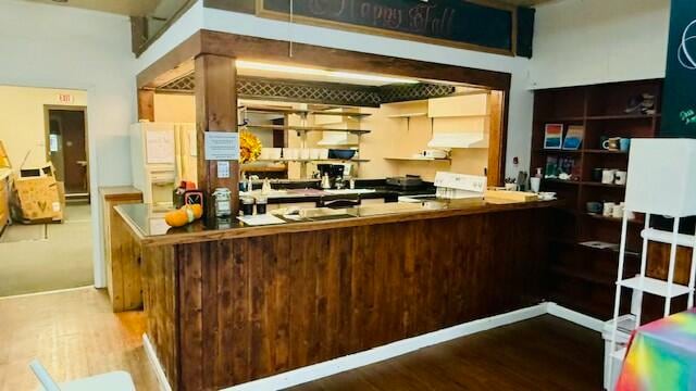 kitchen featuring kitchen peninsula, hardwood / wood-style floors, and stove