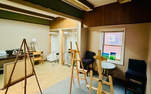 interior space featuring radiator, wooden walls, and beamed ceiling