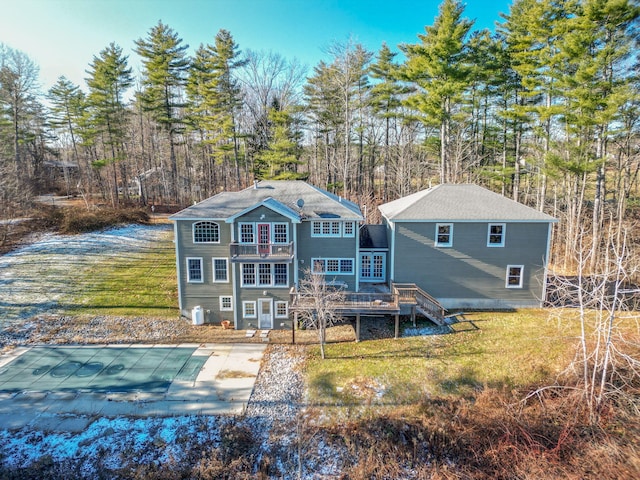 back of house featuring a lawn, a swimming pool side deck, and a balcony