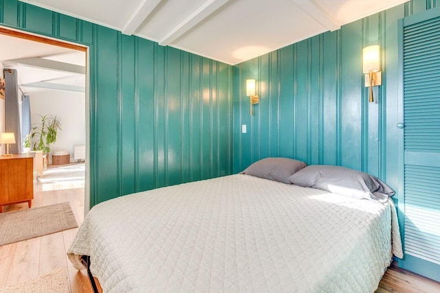 bedroom featuring beam ceiling and hardwood / wood-style flooring