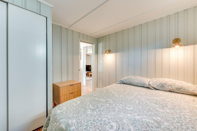 bedroom featuring wooden walls and wood-type flooring