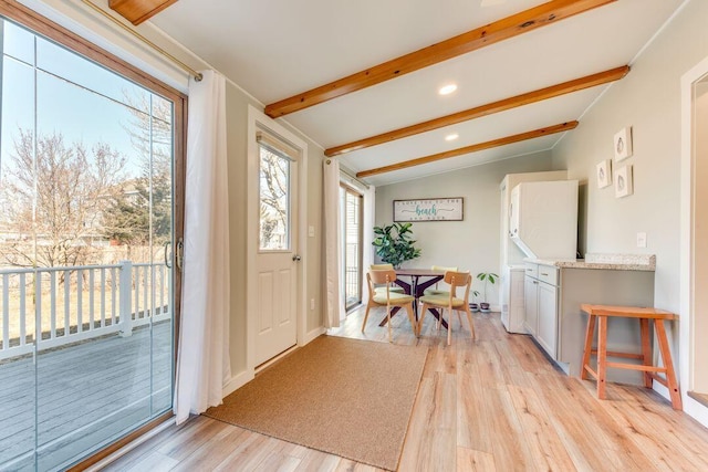 entryway featuring light hardwood / wood-style flooring and lofted ceiling with beams