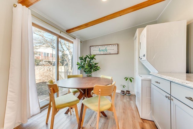 dining area with vaulted ceiling with beams and light hardwood / wood-style flooring