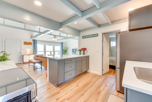 kitchen featuring light hardwood / wood-style flooring, ceiling fan, gray cabinets, kitchen peninsula, and stainless steel appliances