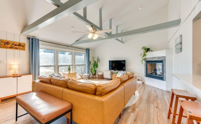 living room featuring a multi sided fireplace, ceiling fan, light hardwood / wood-style flooring, and high vaulted ceiling