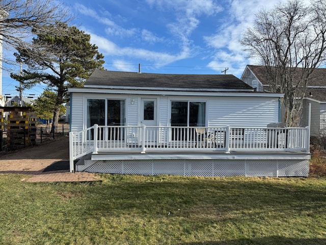 back of property with a yard and a wooden deck