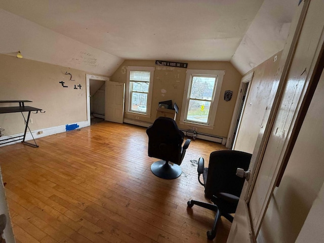 interior space featuring a baseboard heating unit, light wood-type flooring, and vaulted ceiling