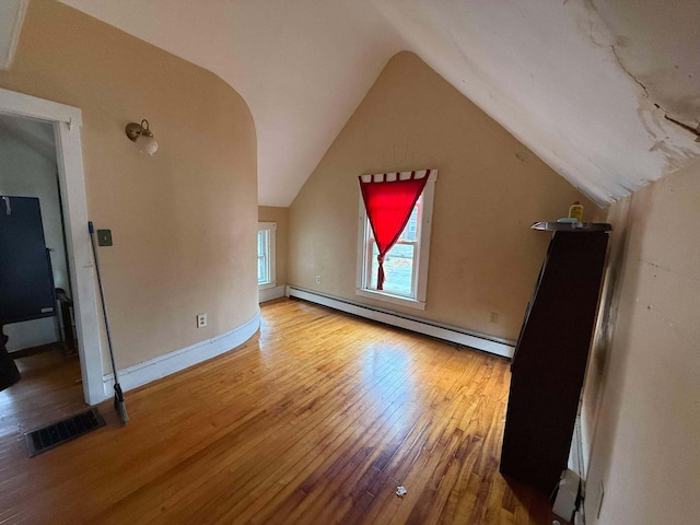 bonus room featuring hardwood / wood-style flooring, baseboard heating, and vaulted ceiling