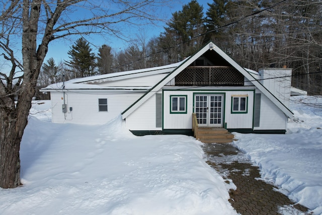 snow covered structure with french doors