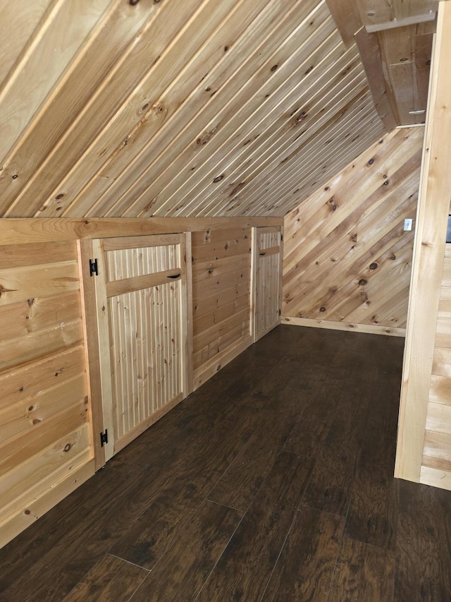 interior space featuring wood-type flooring, wooden walls, and vaulted ceiling