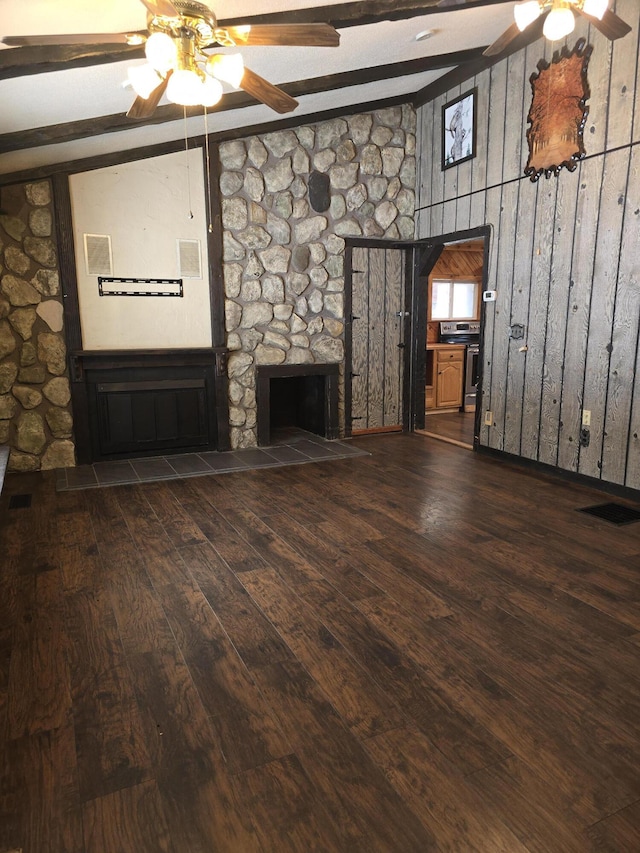 unfurnished living room with a ceiling fan, wood finished floors, visible vents, lofted ceiling with beams, and a fireplace