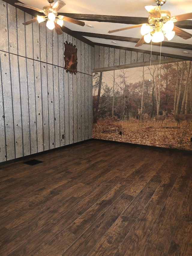 spare room featuring lofted ceiling with beams, wood finished floors, visible vents, and ceiling fan