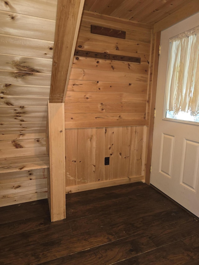 additional living space with dark wood-type flooring, wooden walls, and wood ceiling