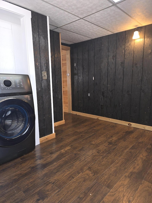 interior space with wooden walls, washer / dryer, wood finished floors, and laundry area