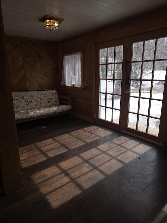 doorway to outside with french doors, wood-type flooring, and wooden walls